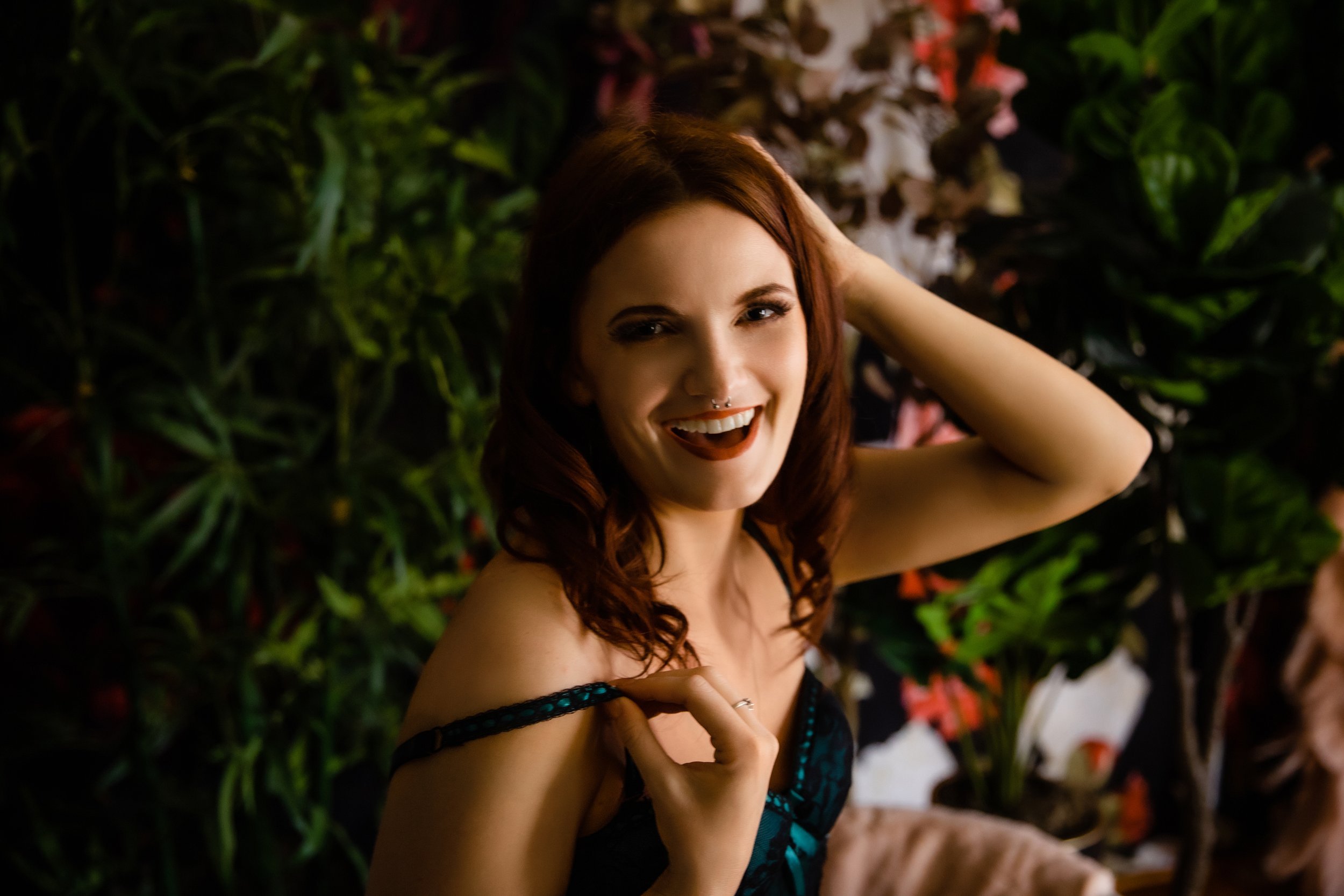 A woman in a green dress posing for a photo at the New Boudoir Studio.