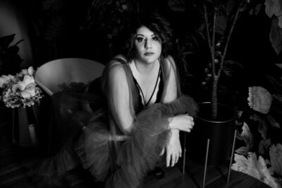 A black and white photo of a woman in a tulle dress, featured in a Boudoir Gallery.