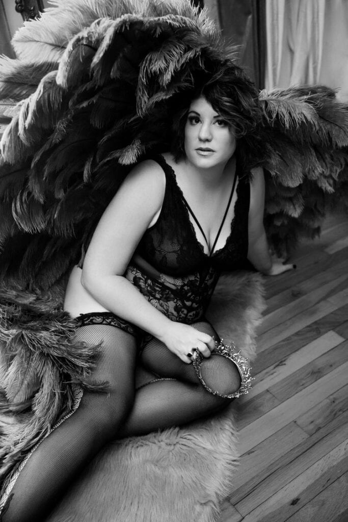 Black and white photo of a woman in lingerie for a photoshoot.