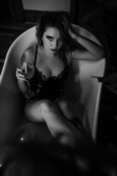A woman sitting in a bathtub, captured by an Indiana Boudoir Photographer.