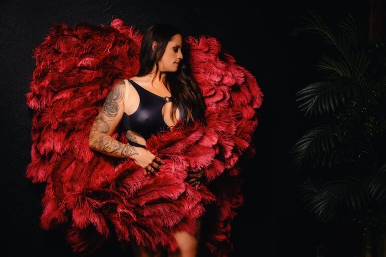 Woman with large red feather wings.